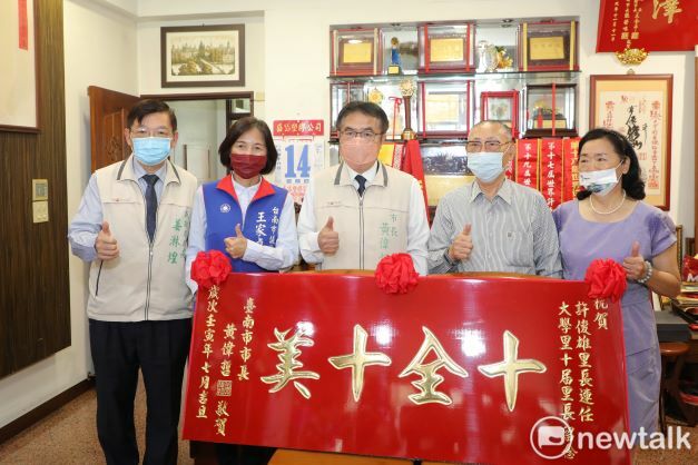台南市東區大學里長許俊雄連任十屆服務在地40年，台南市長黃偉哲為感謝其辛勞付出，今（14）日偕民政局長姜淋煌至許里長家中致贈紅匾以彰其德，並讚揚許俊雄「十全十美」為民服務奉獻。 圖：黃博郎／攝