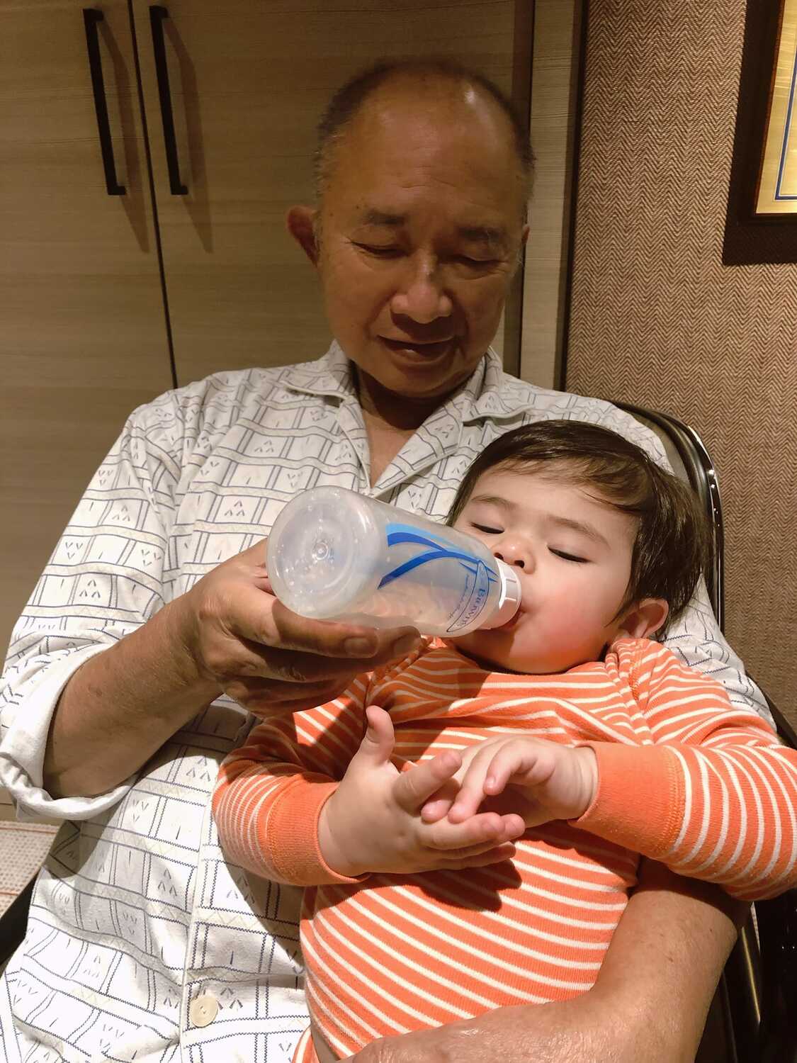 吳宇森導演私下也做奶爸,餵孫吃奶。