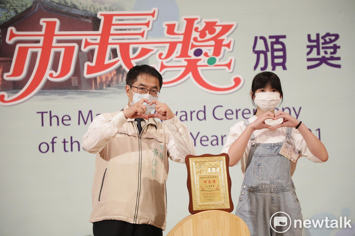 黃偉哲親和力十足的配合同學們創意多元的擺拍姿勢，期盼為畢業生留下快樂美好的回憶。 圖：台南市政府提供