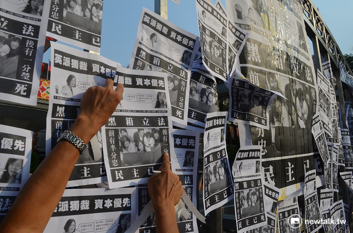 抗議勞工在立法院大門貼上印有總統蔡英文照片，以及民進黨立委陳瑩照片的傳單。 圖：柯昱安/攝