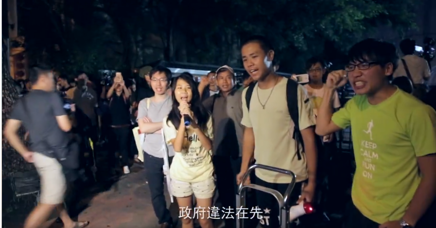 邵啟月當年國中剛畢業，就上街反黑箱課綱，拿著麥克風在警察面前高喊「政府違法在先、學生抗議無罪」。 圖：擷自紀錄片「暴民」