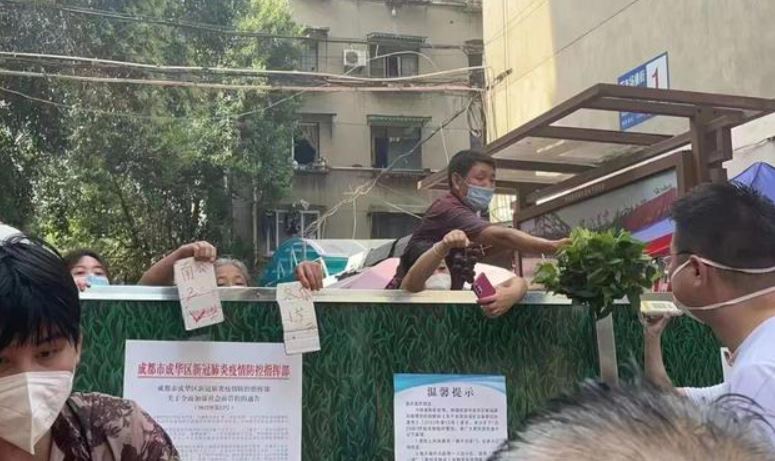 成都民眾與攤販隔牆交易。 圖:翻攝自網易