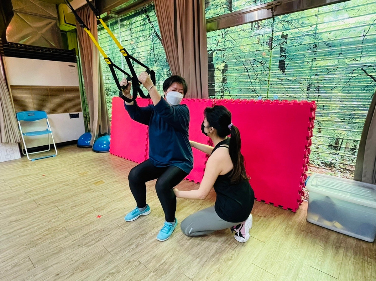 新莊運動中心運動指導員指導長者TRX動作要領。 圖：新北市體育處/提供