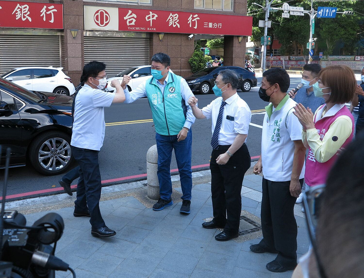 民進黨新北市長參選人林佳龍參加新北市黨部舉辦的「爸氣十足健康88父親節健康市集」，新北市黨部主委何博文等人在入口處與林擊肘歡迎。 圖：民進黨新北市黨部提供