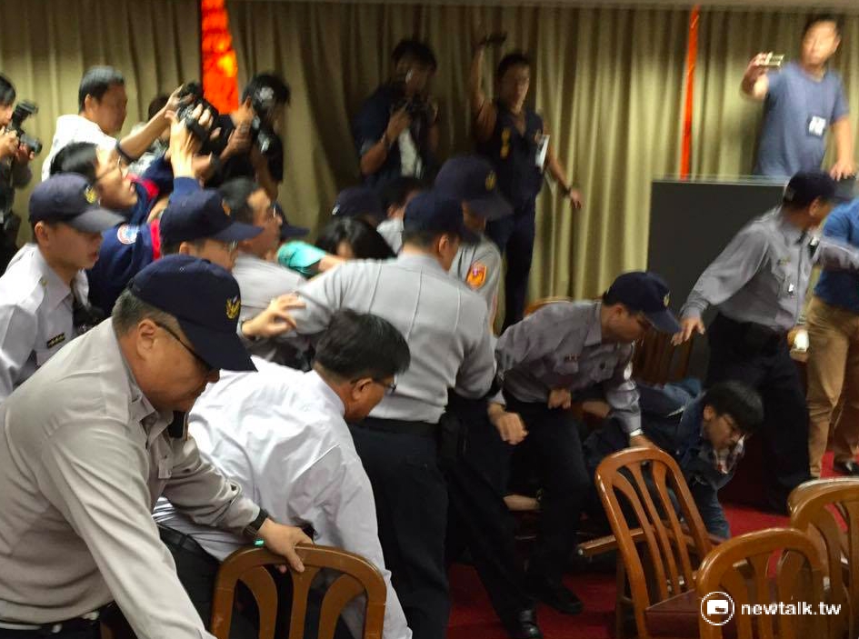 《勞基法》修正案16日舉辦公聽會引發暴力衝突，主席陳瑩在警察護送下，進入休息室中。 圖：鄭佑漢/攝