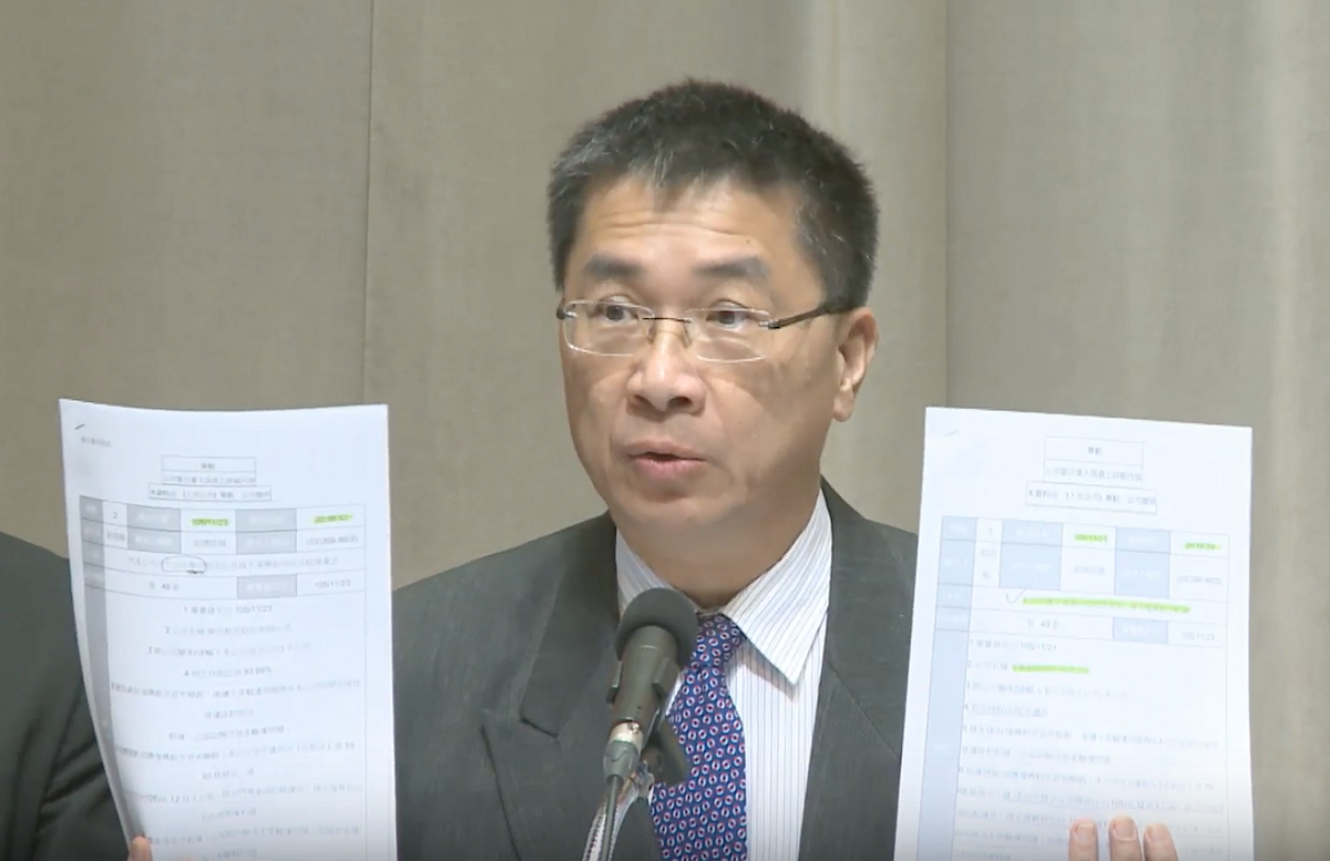 行政院發言人徐國勇拿出華航與華信的重大訊息揭露，強調上面的內容，與他23日轉述的「華航全面接手復興航空航線」一模一樣。 圖：翻攝自行政院直播畫面