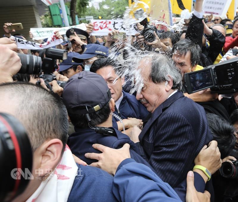 勞團成員朝民進黨立法院黨團總召柯建銘潑水。 圖：中央社