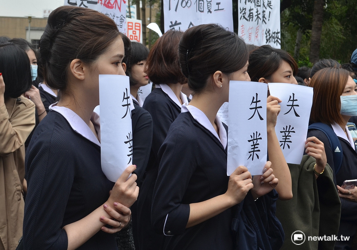 復興航空空服員舉起「失業」字卡，淚眼期盼行政院能介入處理。 圖：柯昱安/攝