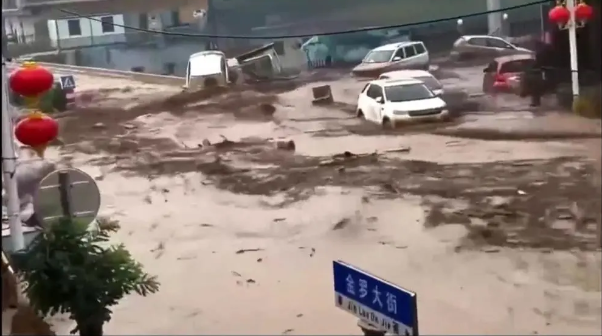 山西省呂梁市中陽縣金羅鎮街道上，可見許多車輛被洪水沖走。