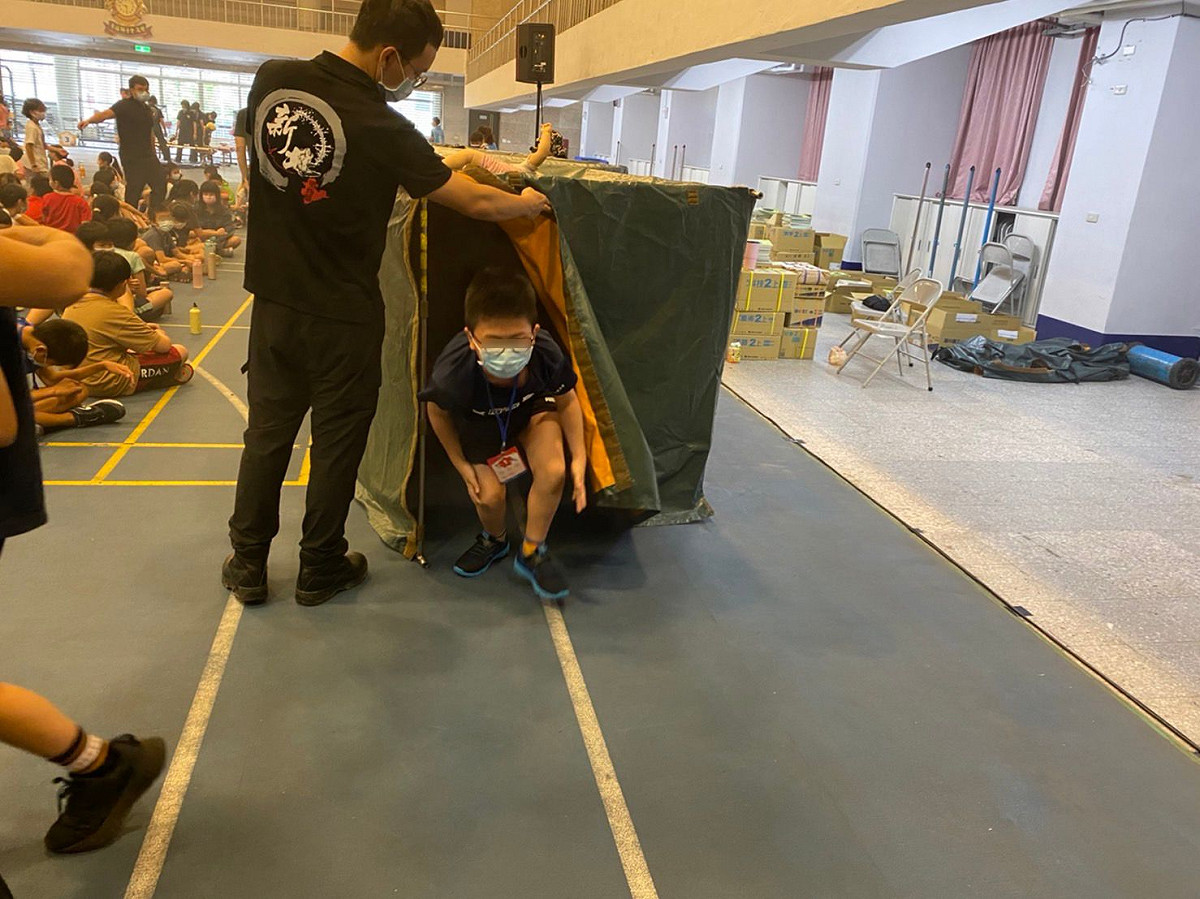 新北消防夏令營今(111)年特色亮點項目，在活動中加入侷限空間救援要素，讓學童穿越充滿人造煙的隧道內，模擬黑暗且未知的環境下，救出內部受困目標 圖：新北市消防局提供