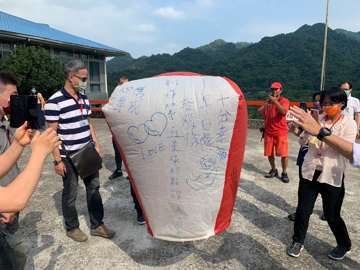 新北市政府民政局在平溪十分風景區舉辦單身聯誼活動，單身男女施放天燈祈願幸福。 圖：新北市民政局提供