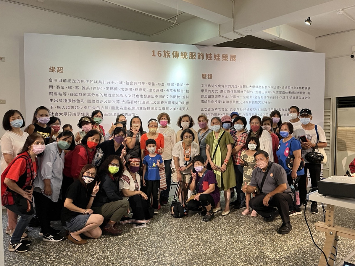 新北原民局長羅美菁(圖中橘色上衣者)穿戴泰雅族頭飾及織布片裙，歡迎工作坊指導老師田宇寧老師以及學員開心回來觀展。 圖：新北市政府原民局提供