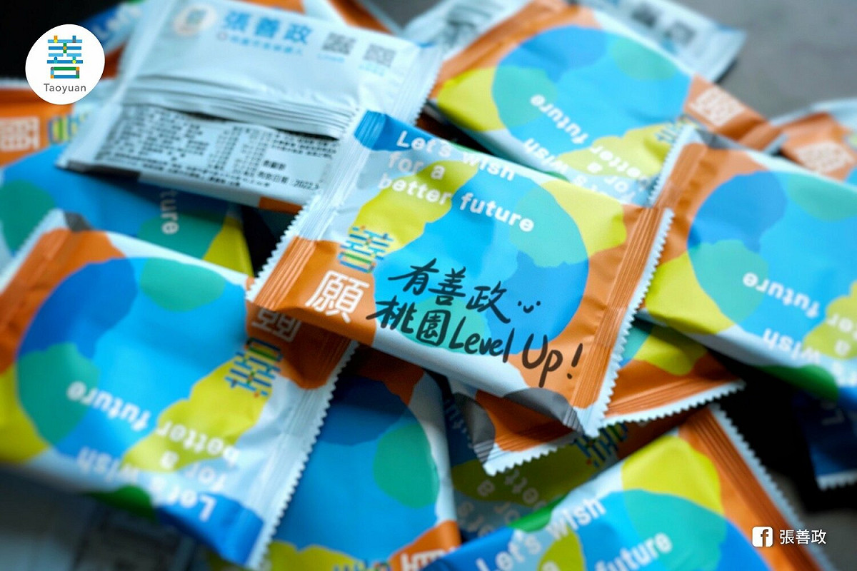 張善政最新的競選小物「善願餅」以7色手繪幾何圖形做外包裝，裡面的餅乾則是由桃園在地知名業者生產。 圖：翻攝張善政臉書