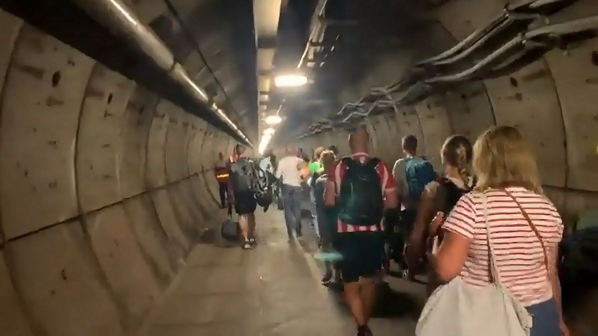 英法海底隧道內的火車拋錨後，民眾用走路的方式離開。 圖: 翻攝自推特影片截圖