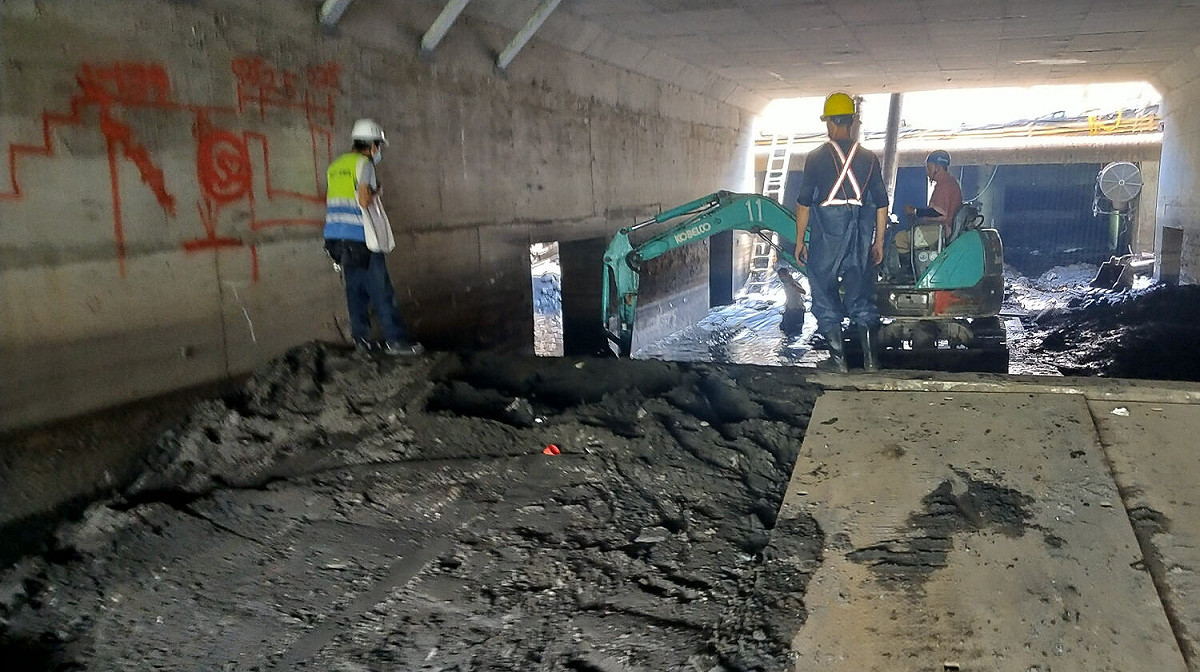 施工人員於萬福橋下方狹小空間進行清淤。 圖：新北市水利局提供