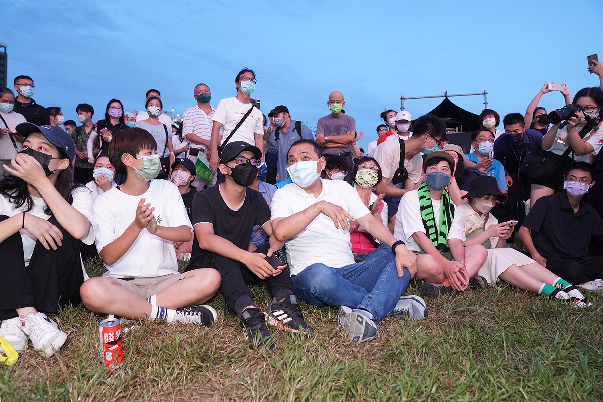新北市長侯友宜與年輕朋友一起席地而坐，跟著獨立音樂搖滾。