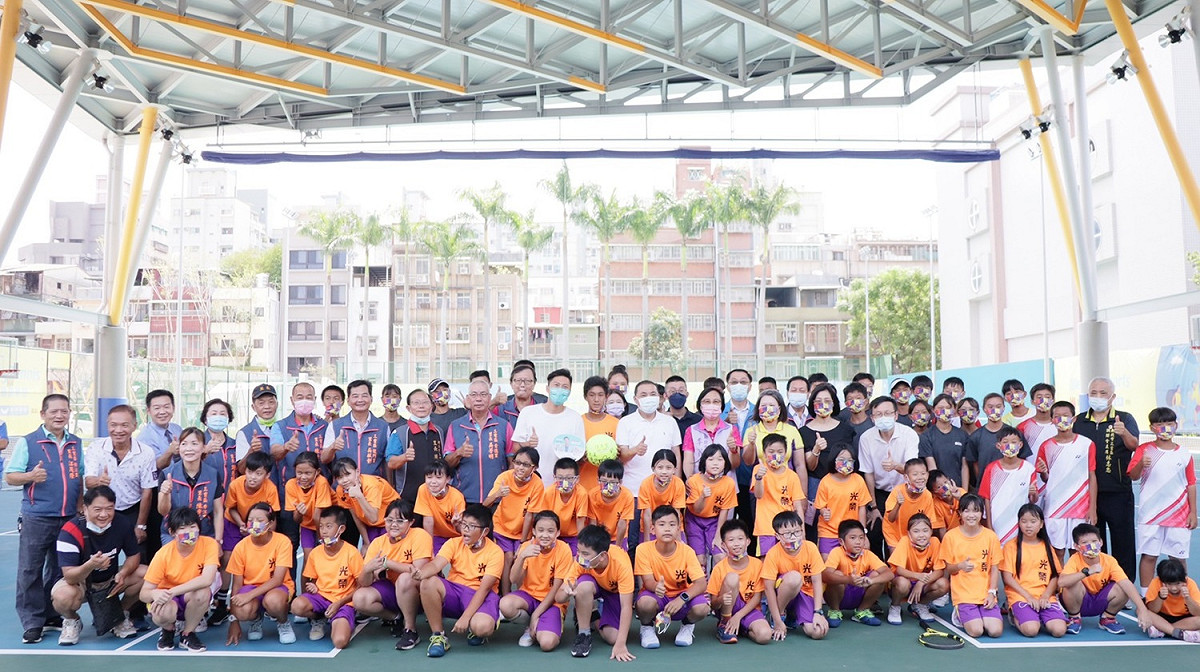 侯友宜第3次造訪光榮國小監督校舍改建工程，並與光榮國小網球隊及來賓在改建工程最後一塊拚圖-風雨操場上合照。 圖：新北市工務局提供