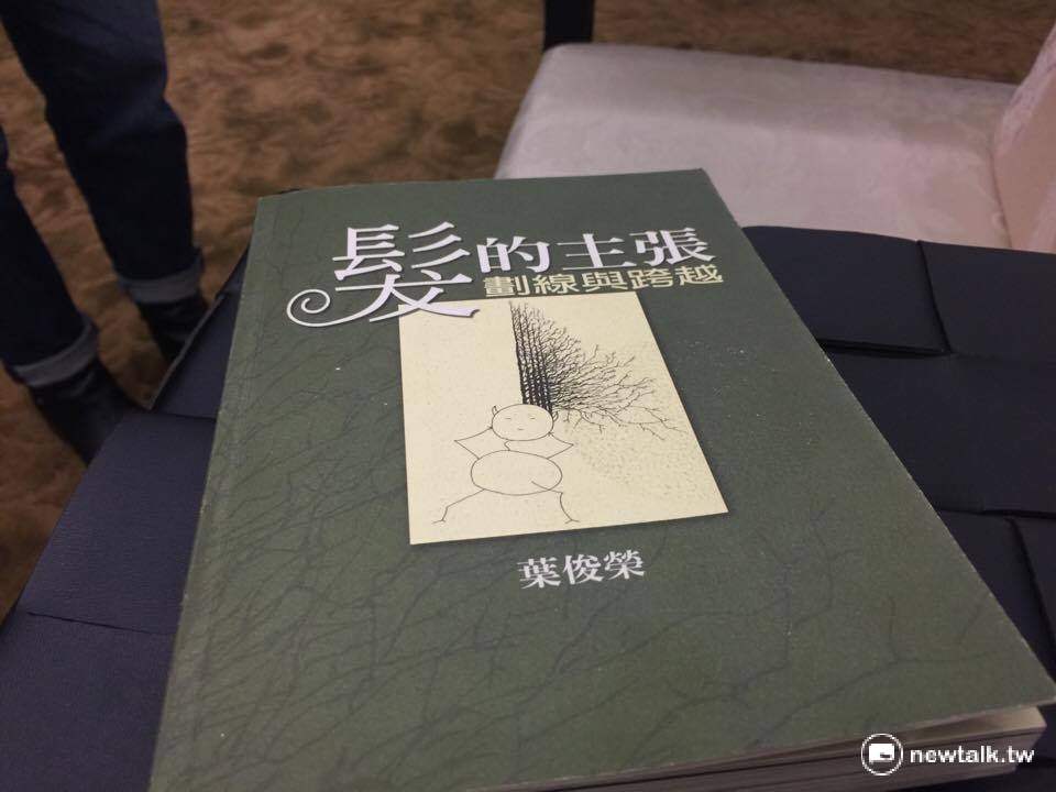 葉俊榮拿出過去出版的繪本《髮的主張》，證明自己也曾經是「插畫家」。 圖：柯昱安/攝