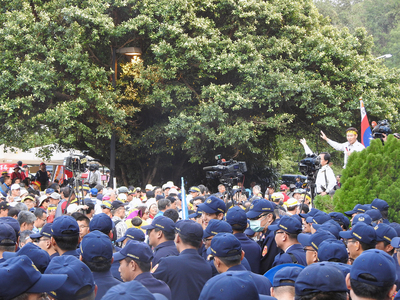 年金改革中區座談會場外爆發幾波衝突，造成了部分出席人員被抗爭群眾圍堵阻撓，無法進入會場報到參與會議。 圖：中央社