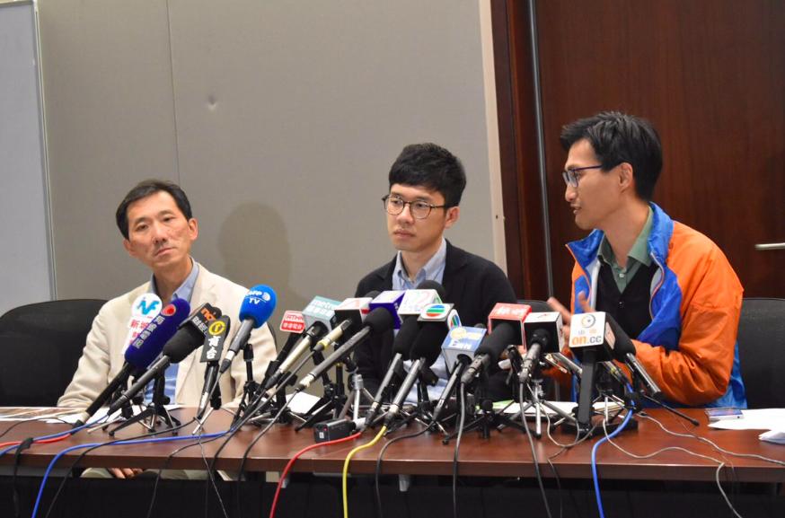 「香港眾志」議員羅冠聰(中)8日晚間結束訪台行程返回香港，卻在香港機場接機大廳遭到群眾圍毆，造成身上多處受傷。他在9日下午召開記者會譴責親中人士的暴力行為。 圖：翻攝香港眾志臉書