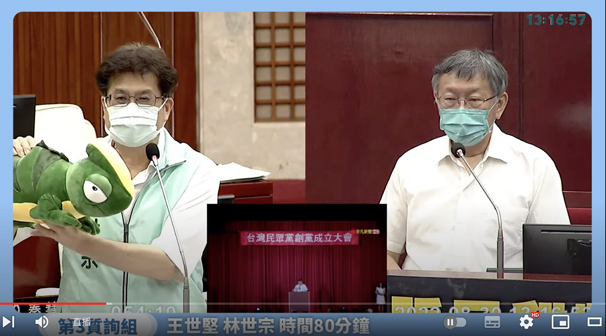 民進黨市議員林世宗酸市長柯文哲宛如「變色龍」，還拿一隻變色龍娃娃。 圖：翻攝直播