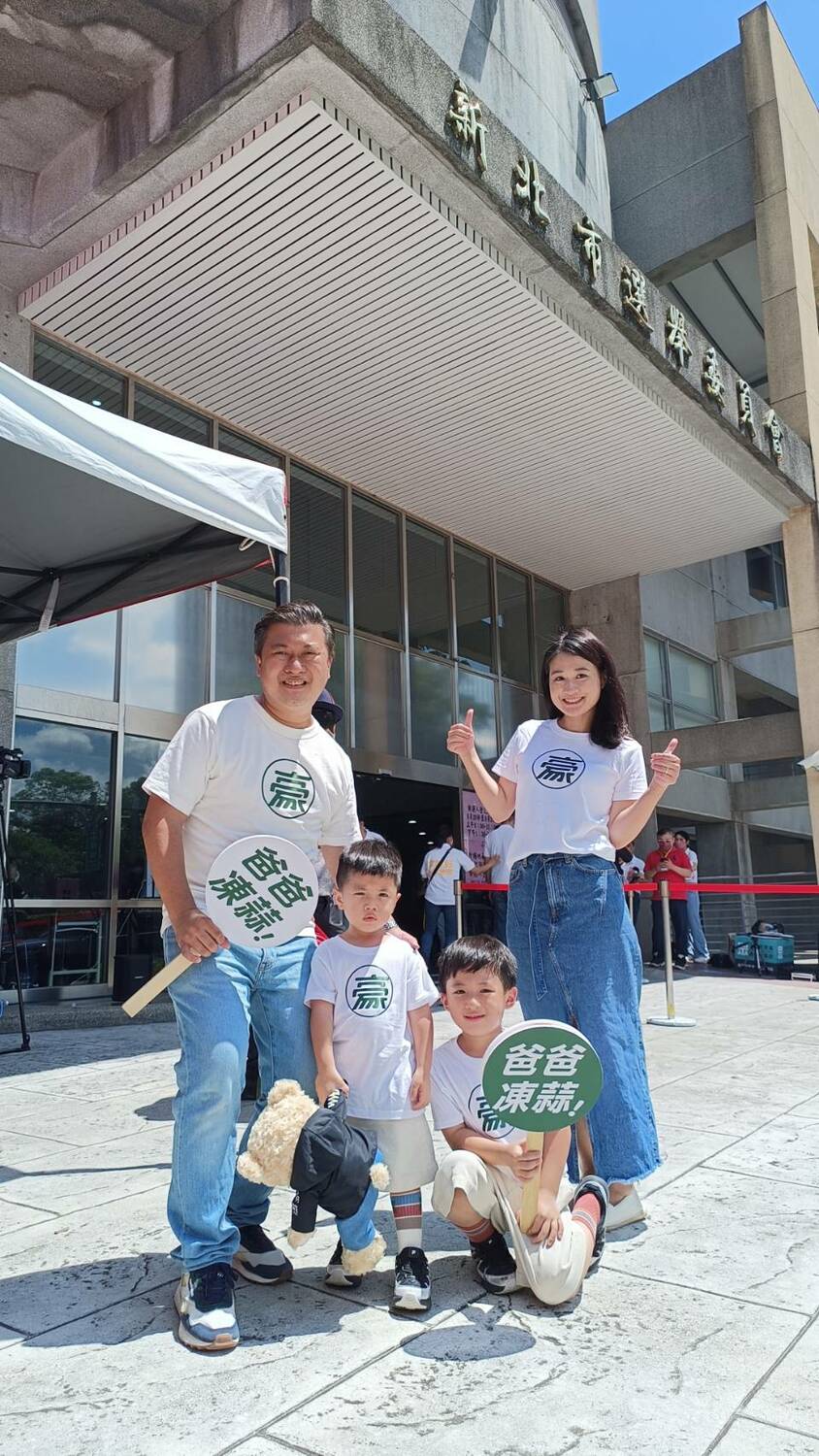 張志豪帶著身穿「爸爸凍蒜」衣服的兩個兒子，夫妻帶著兩個兒子四人同穿親子裝前往新北市選委會登記。 圖：張志豪辦公室提供