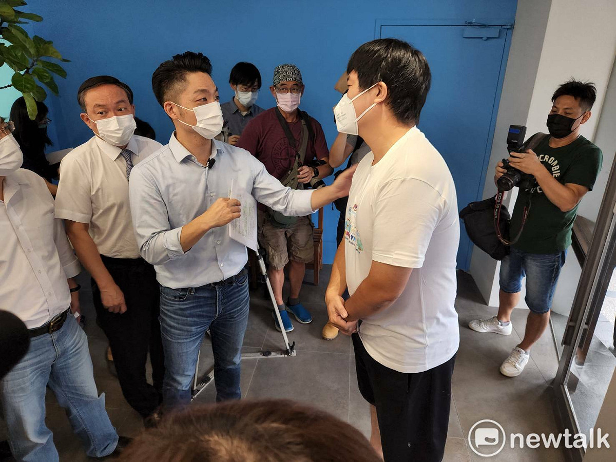 在私人長照機構任職的林先生，身穿便衣、拖鞋，剛好路過蔣萬安的政見發表會。在記者會場地外，林先生的女兒也在外頭張望，看到爸爸與蔣萬安、媒體互動結束後，才上前趴在爸爸腿上，問爸爸剛在幹嘛？ 圖：黃建豪/攝
