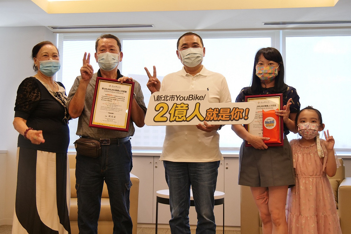 新北市長侯友宜今天頒予證書給新北YouBike第2億及前一位騎乘人次幸運兒。 圖：新北市交通局提供