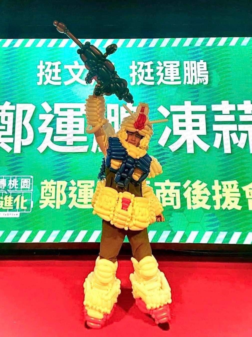 民進黨桃園市長參選人鄭運鵬獲桃園青商會力挺，後援大會成立滿滿動漫風，他在個人臉書上po疑似借穿工作人員氣球鋼彈裝照片，喊全台最歡樂。 圖：翻攝自鄭運鵬臉書
