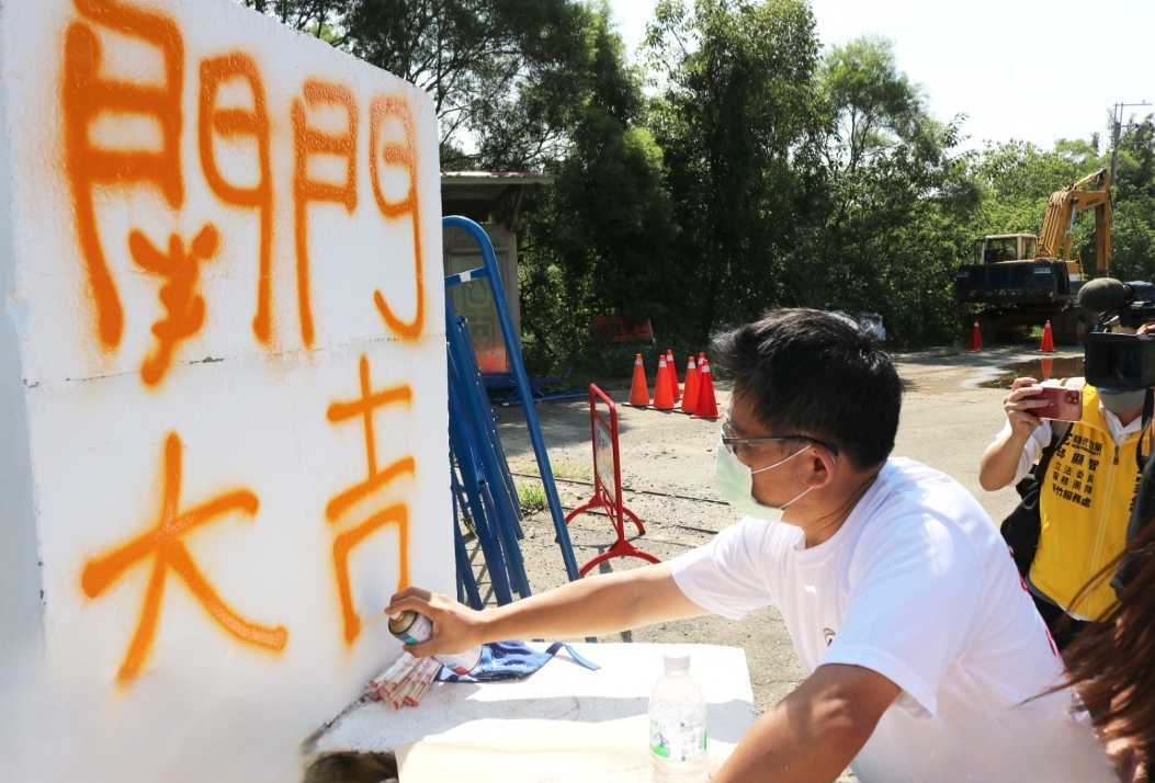 立委邱顯智在坤輿案抗爭勝利現場，在水泥塊上噴上「關門大吉」，宣告抗爭勝利。 圖：翻攝自邱顯智臉書