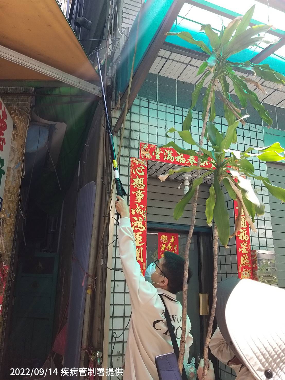 防疫人員於高雄市前鎮區執行孳生源查核，協助民眾檢視家戶外遮雨棚是否有積水產生 圖：疾管署／提供