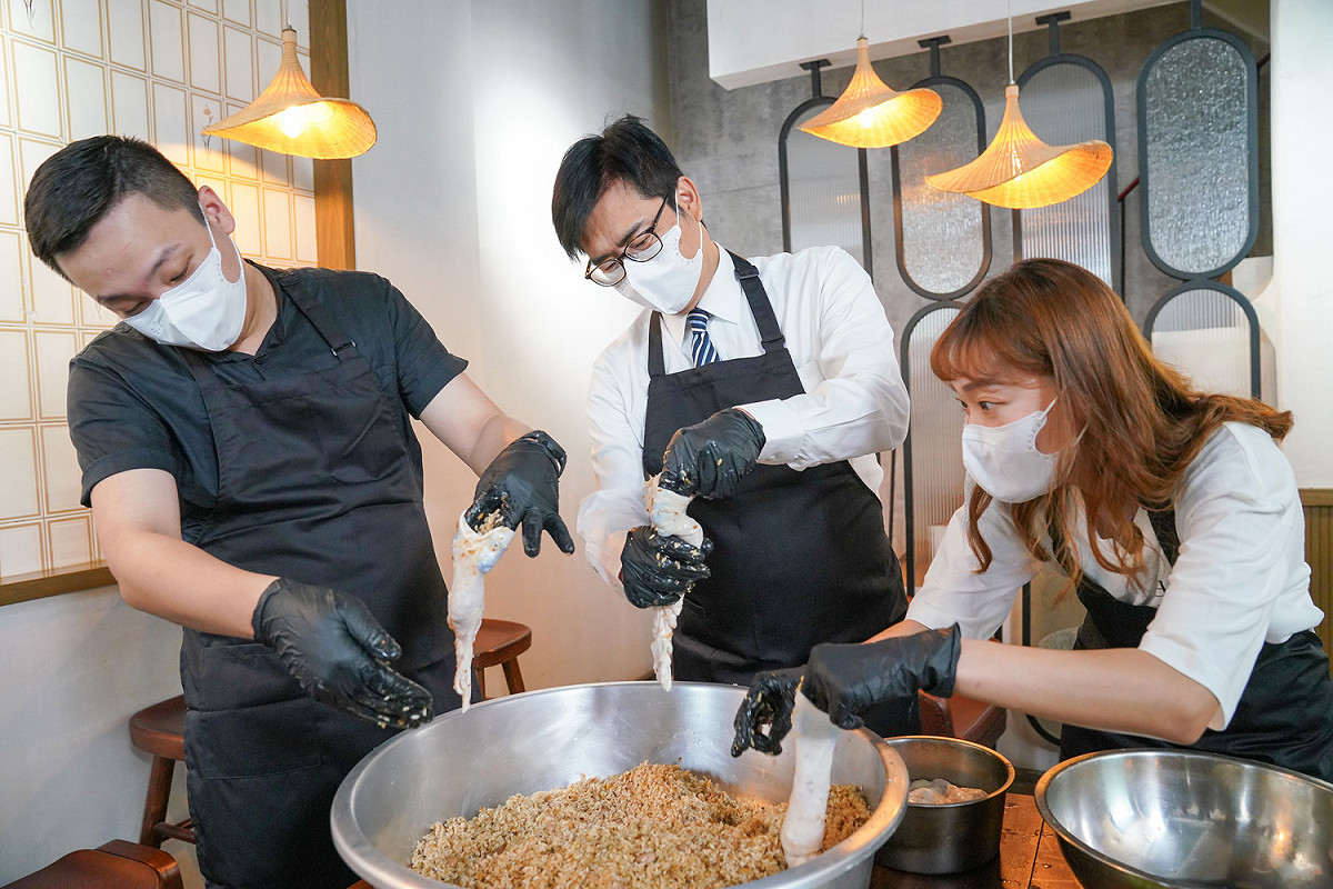 陳其邁(中)體驗灌糯米腸。 圖：高雄市政府提供