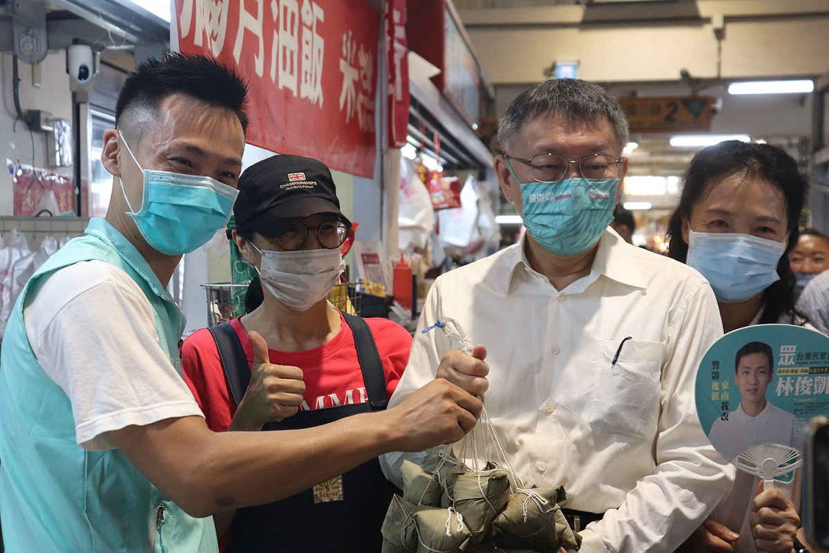 柯文哲陪林俊凱拜票，攤商致贈粽子象徵包中。 民眾黨/提供