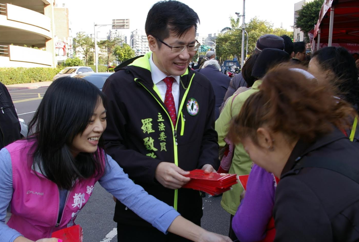 新北市議員鄭宇恩與立委羅致政22日在淡水舉辦「迎新春、賀新年、送春聯」的活動，包並贈送各款春聯及紅包袋給往來民眾賀歲拜年。 圖：新北市議員鄭宇恩辦公室提供