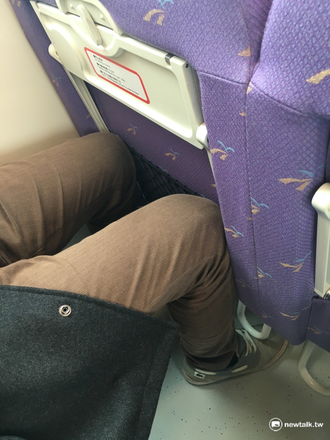記者實測，一名180公分、中等身材男性乘坐時，膝蓋會頂到前方座椅，伸展空間有限。 圖：柯昱安/攝