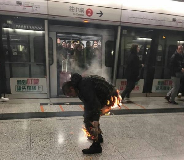 香港一列地鐵10日晚間在九龍尖沙咀站突然起火，導致至少12人受傷。圖為一名乘客身上著火。 圖：中央社(民眾提供)