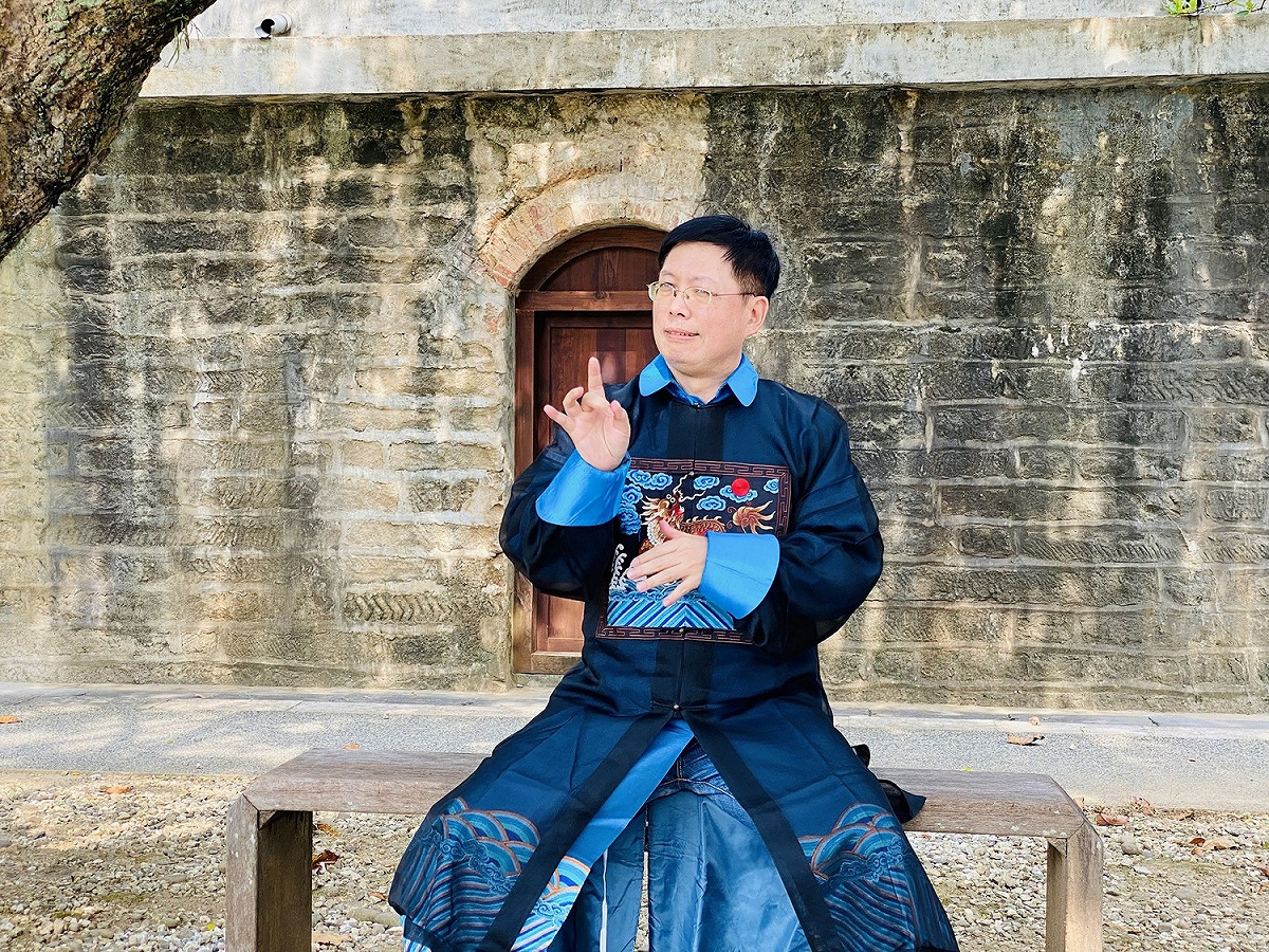 淡水古蹟博物館新上架的台灣手語導覽影片「滬尾礮台」中，神級手譯員李振輝穿上清裝，透過角色扮演來「比」出古蹟的歷史故事與建築特色。 圖：淡水古蹟博物館/提供