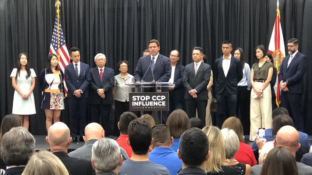 佛羅里達州州長迪尚特（Ron DeSantis，中）簽署行政命令，禁止佛州公部門向中國等威權國家採購可能帶來資安威脅的技術、產品與服務。台灣駐邁阿密辦事處處長紀欽耀（站立者前排右4）美東時間22日受邀出席見證。 圖/駐邁阿密辦事處提供