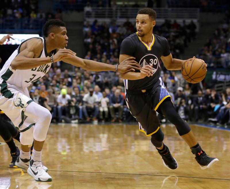 公鹿「字母哥」Giannis Antetokounmpo和勇士超級射手Stephen Curry相互對抗。 圖／美聯社／達志影像