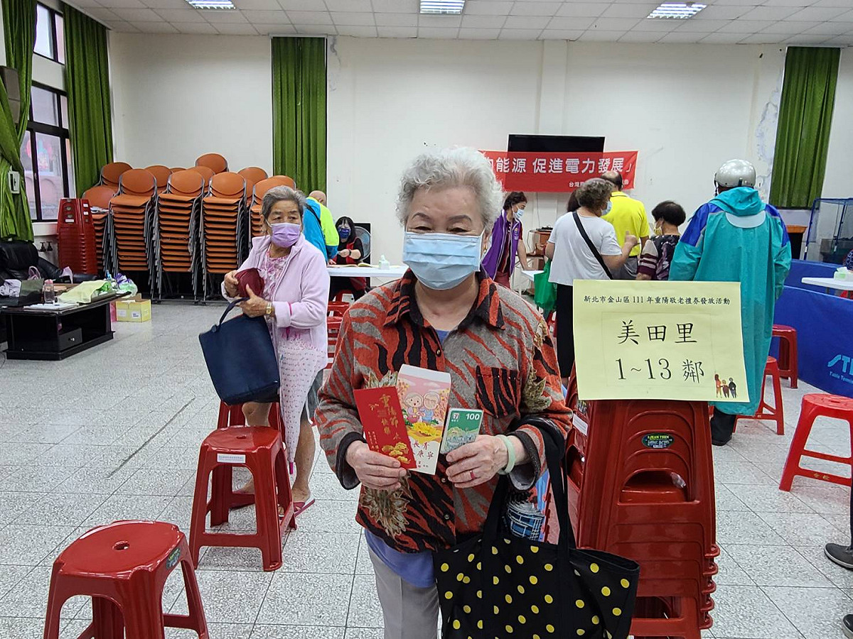 長輩開心拿著重陽敬老禮券及祝賀小卡。 圖：金山區公所提供