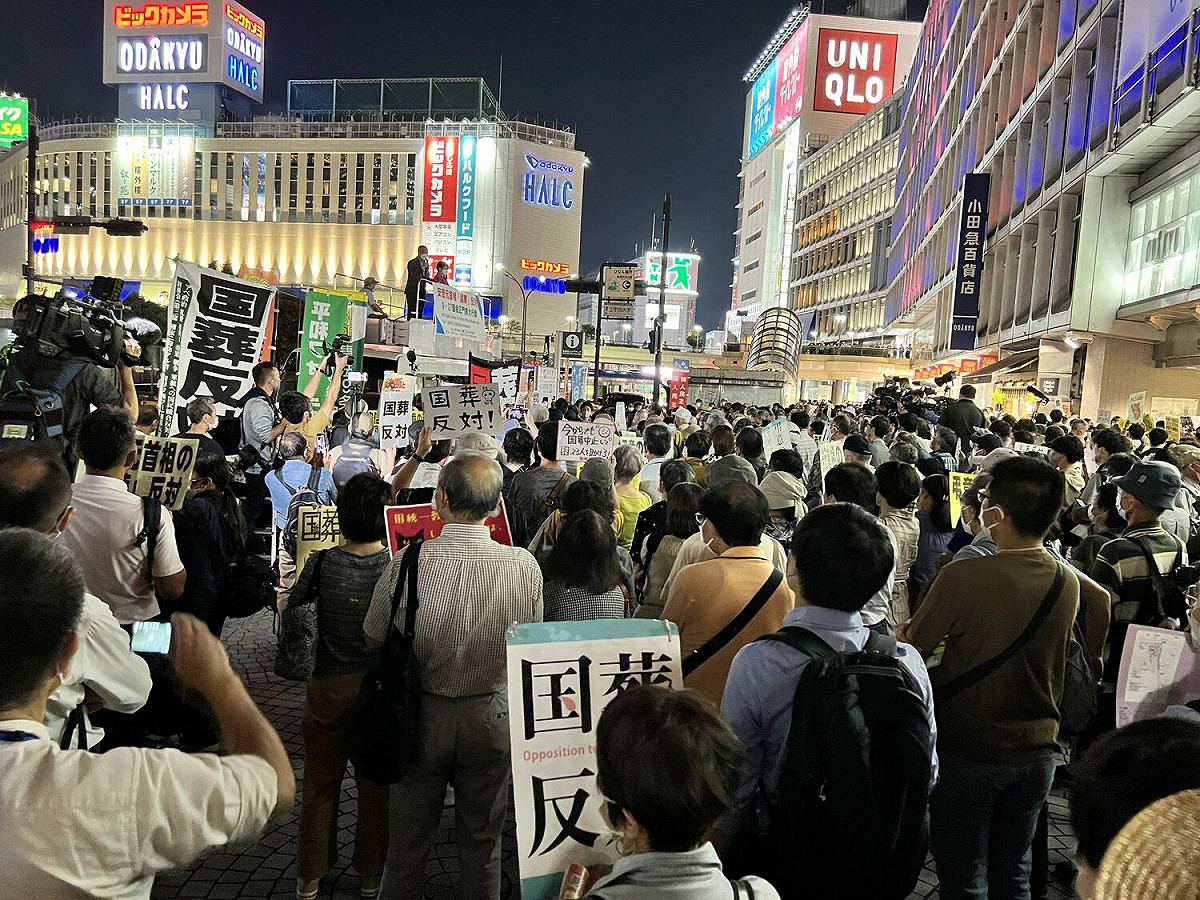 日本東京新宿站外民眾舉著「反對國葬」標語，抗議這次的安倍國葬。 圖：翻攝自推特