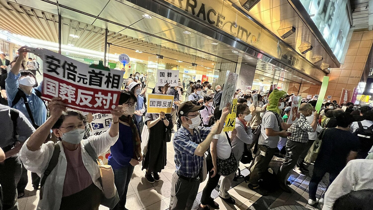 日本東京新宿站外民眾舉著「反對國葬」標語，抗議這次的安倍國葬。 圖：翻攝自推特