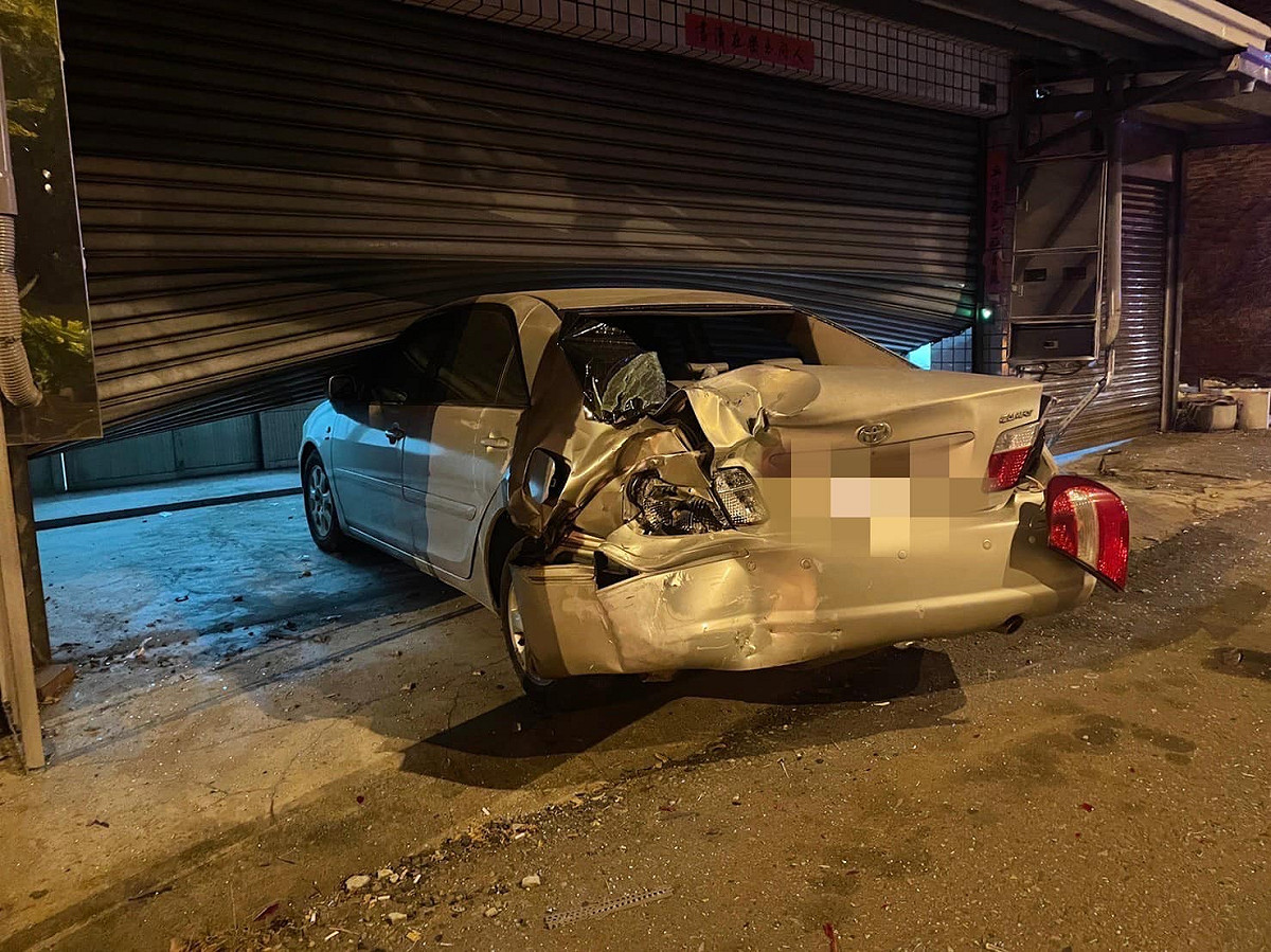 停靠路邊的車輛被撞進公司鐵捲門，導致公司大門、內部嚴重毀損。 圖：翻攝自臉書/含羞草(草爺)