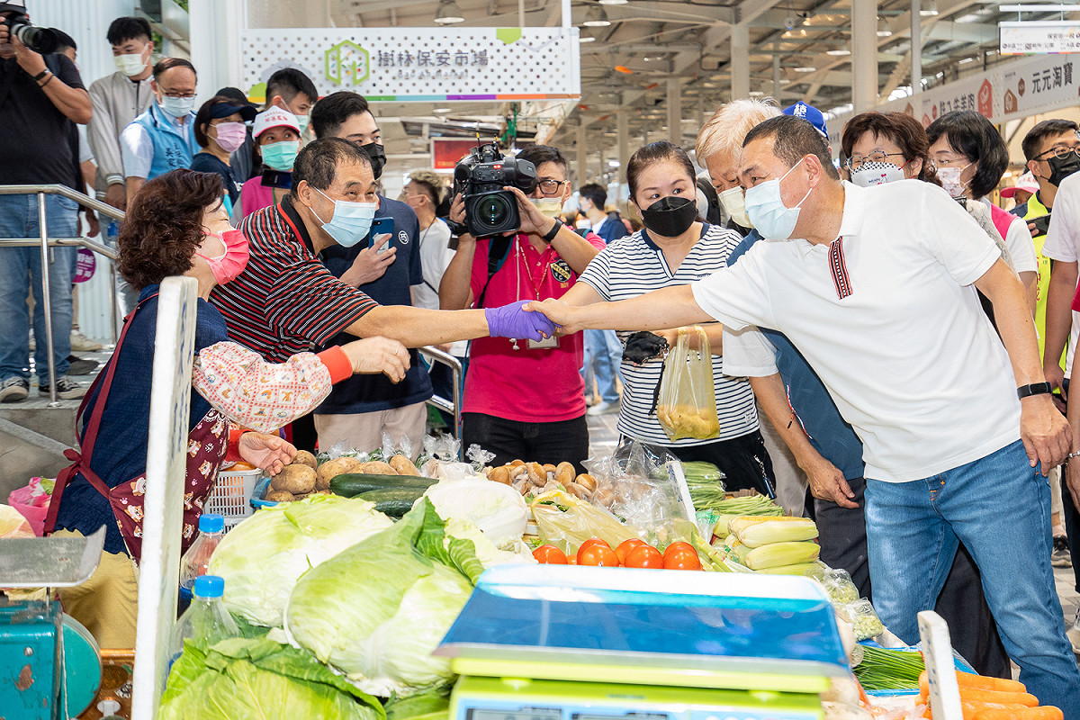市場處於111年10月4日舉辦樹林保安市場開幕典禮，侯友宜與攤商熱情互動。 圖：新北市市場處提供