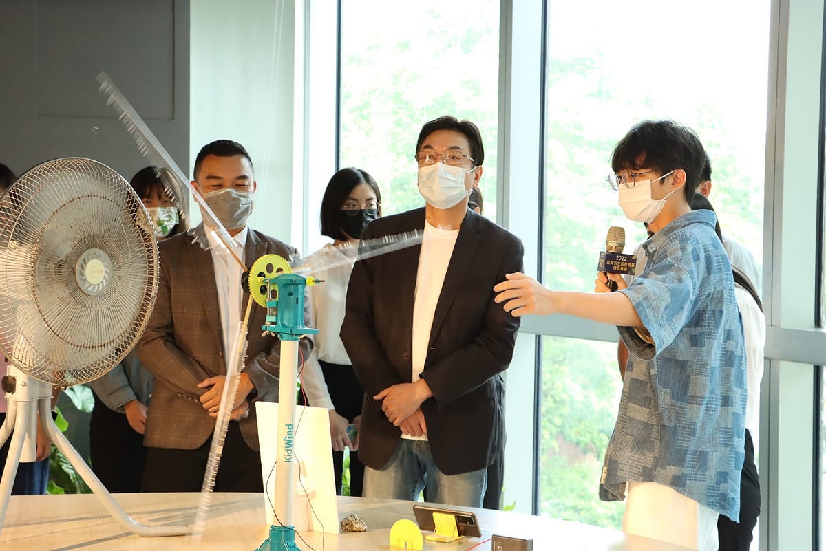 劉和然聆聽台灣科技大學建築系作品「Wind Digester」希望可轉移和降低高層建築表面的風壓，將劣勢轉為優勢同時解決結構問題並提供發電。 圖：新北市漁業處提供