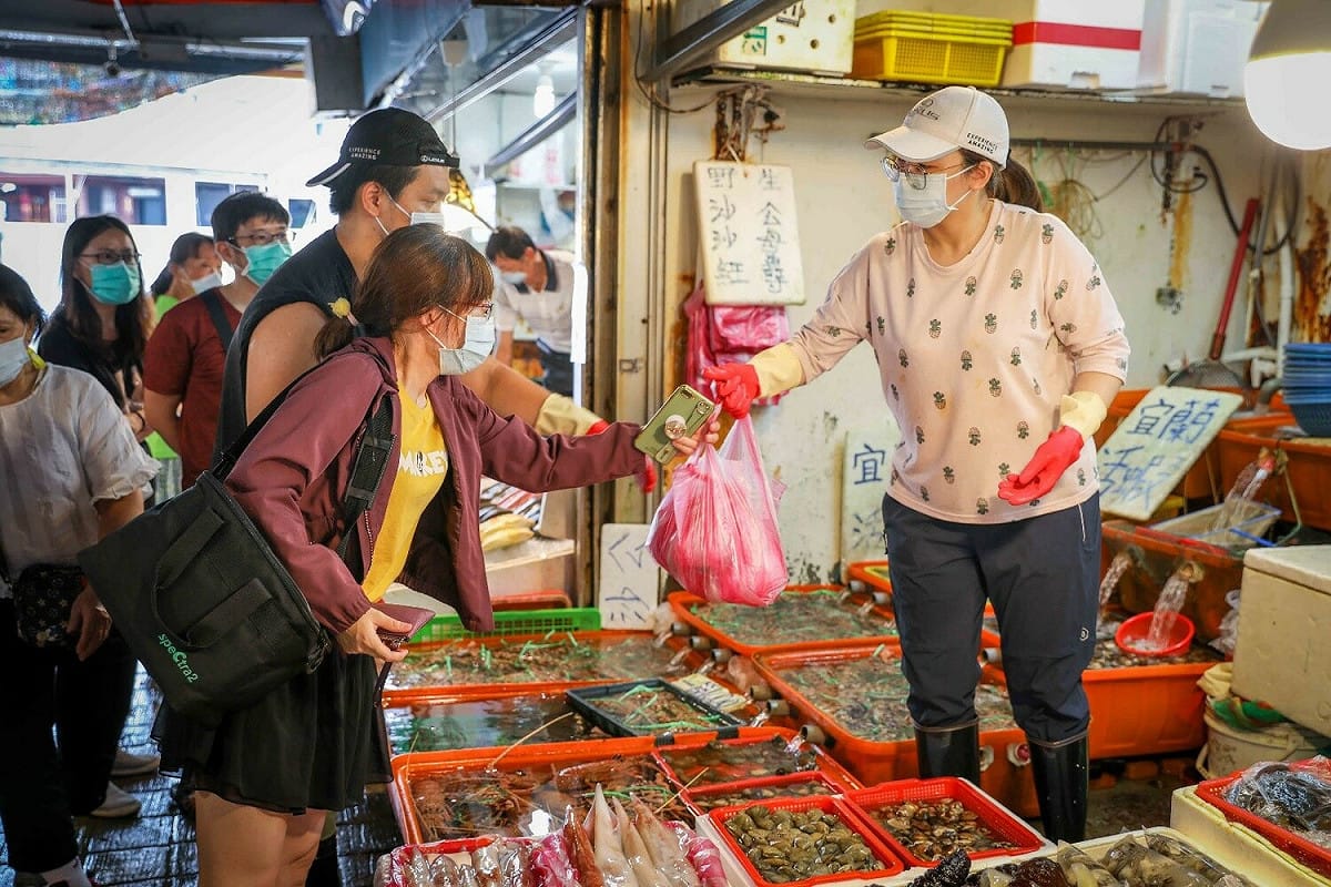 龜吼漁夫市集商家將海產交給消費民眾，攤位上相當多萬里蟹等待挑選。 圖：新北市農業局漁業處提供