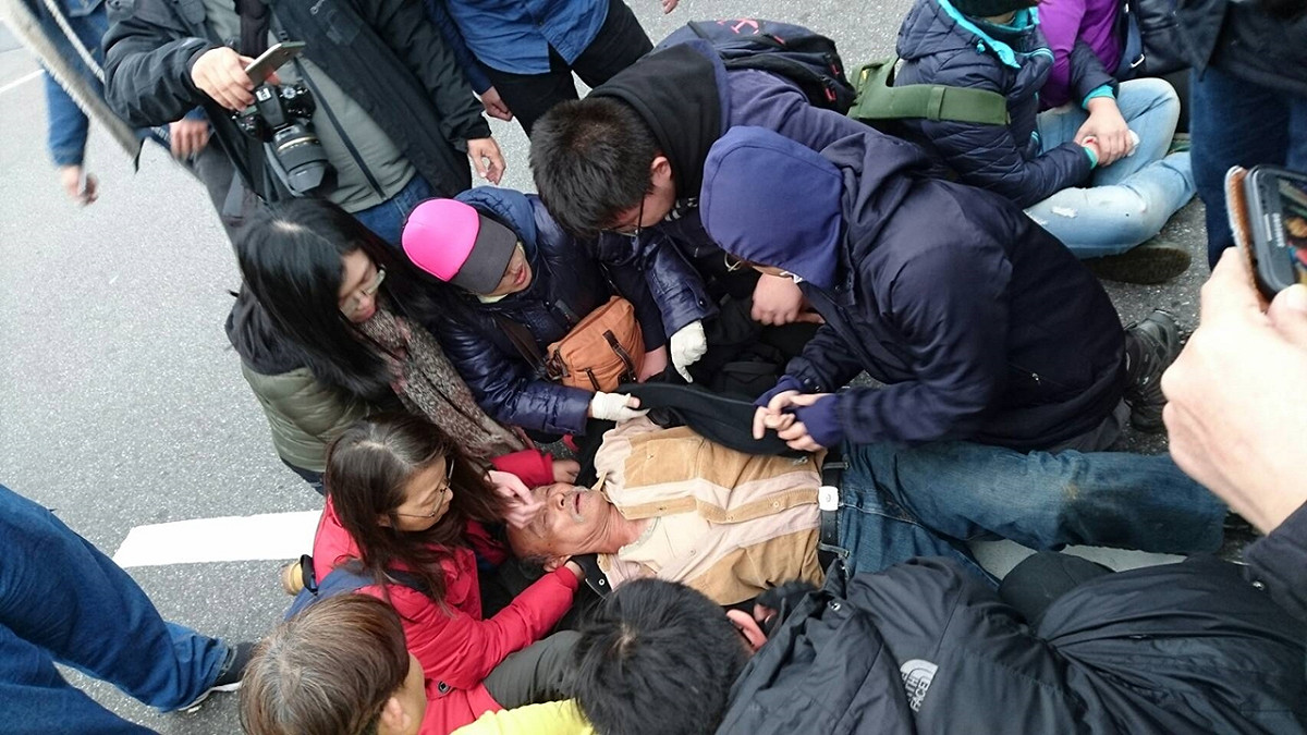為了拆除基隆市火車站前蔣介石銅像，自由台灣黨支持者27日與警方推擠過程中，一位長者暈倒送醫。 圖：讀者提供