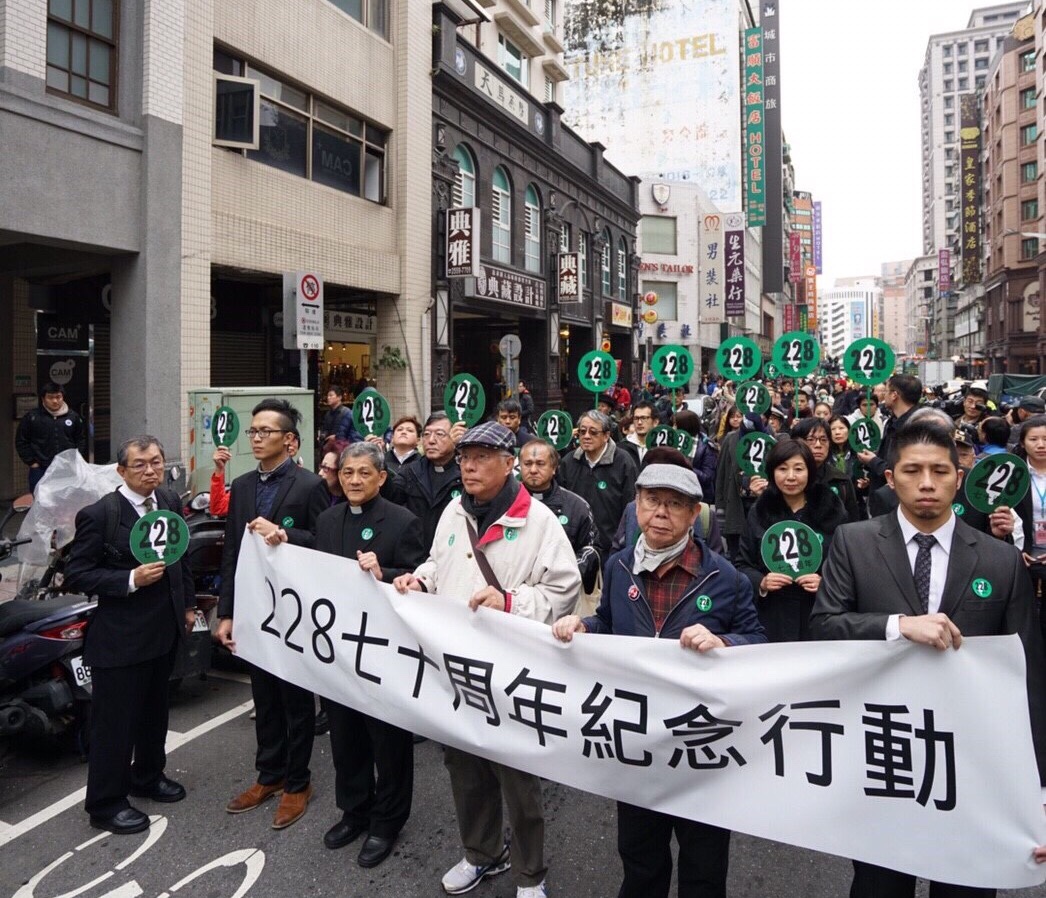 《重返228事件平反遊行》台北遊行現場：台北的第一站，是從「天馬茶馬」開始。28個公民團體2月27日「228. 0 走尋真相—228七十週年紀念行動」，由1987發起成立《228和平促進會》會長陳永興(中白外套)及當年陪同鄭南榕走在遊行隊伍第一排林宗正牧師、李勝雄律師擔任領導。左ㄧ，手持圓牌海報的是鄭南榕弟弟鄭清華。 圖：黃裕順提供