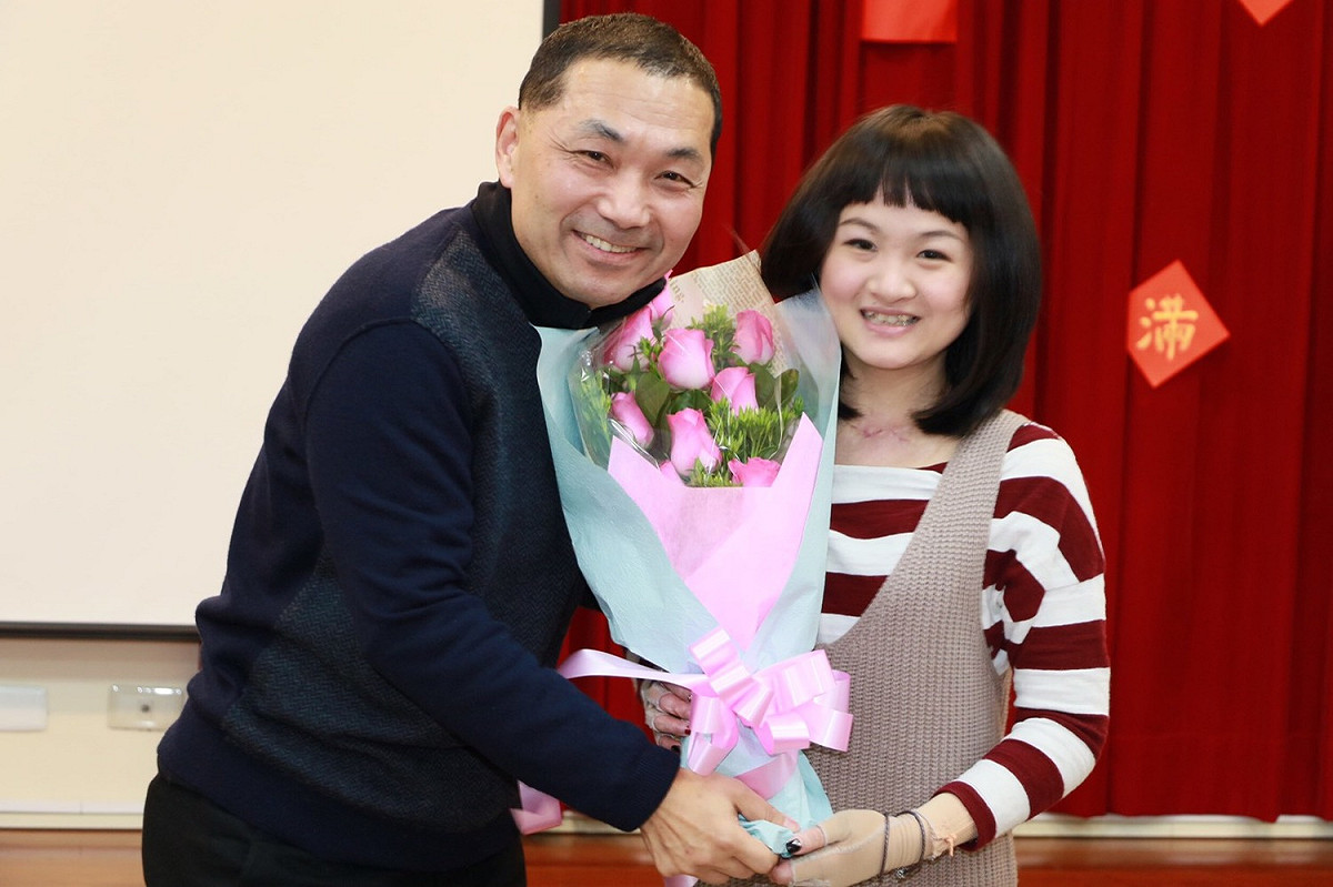 侯友宜接受傷友葉如畇獻上親手作的玫瑰花束。 圖：新北市社會局提供