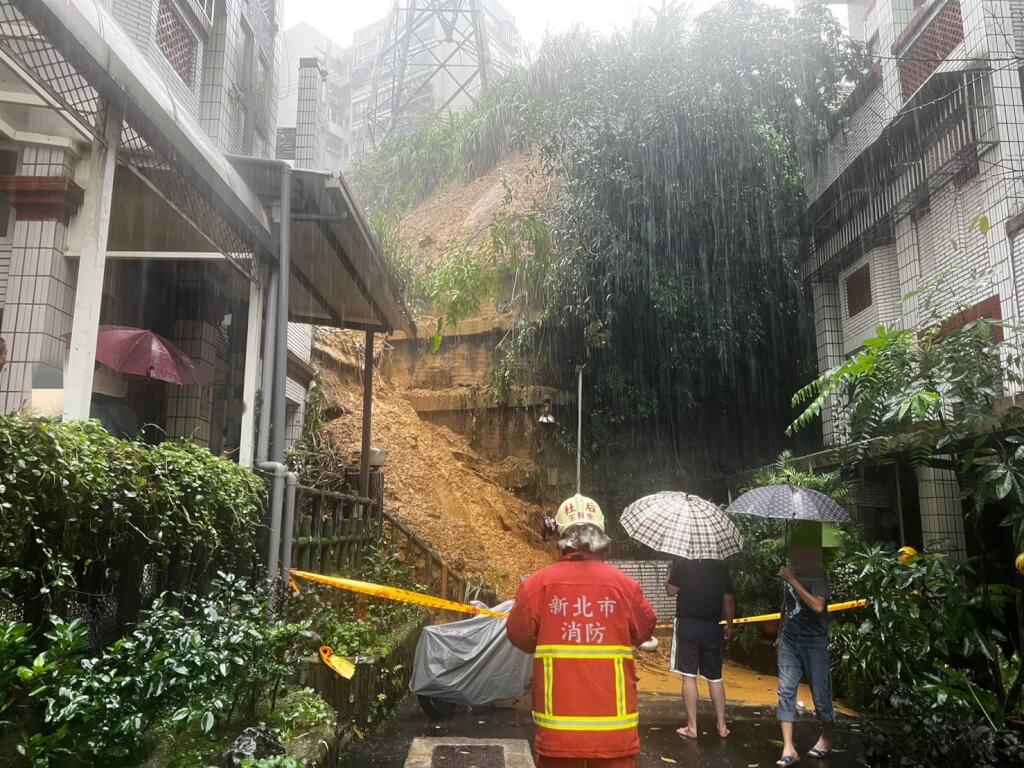 新北市汐止區伯爵山莊社區16日下午出現土石流與土石崩落，有住家陽台鐵窗遭石頭砸毀，目前社區內3戶共11人已撤離至社區活動中心。（翻攝照片）